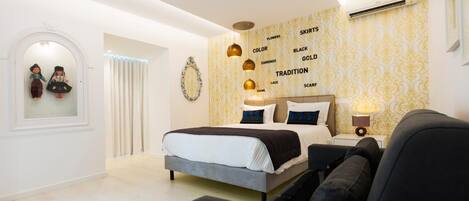 Un dormitorio moderno con una cama, mesita de noche, lámpara y una pared con texto decorativo.