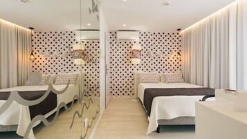 Una habitación de hotel moderna con dos camas, un separador de vidrio y paredes con diseño.