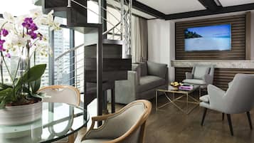 Loft, vista a la ciudad | Área de sala de estar | Televisión LED de 65 pulgadas con canales por cable y Smart TV
