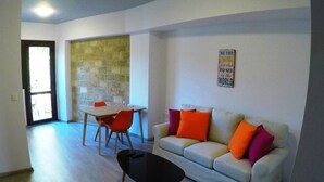 Un salon comprenant un canapé, une table basse et une table à manger avec des chaises.