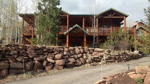 A large wooden lodge with multiple balconies and a stone retaining wall. - Jeremy House (Park City)