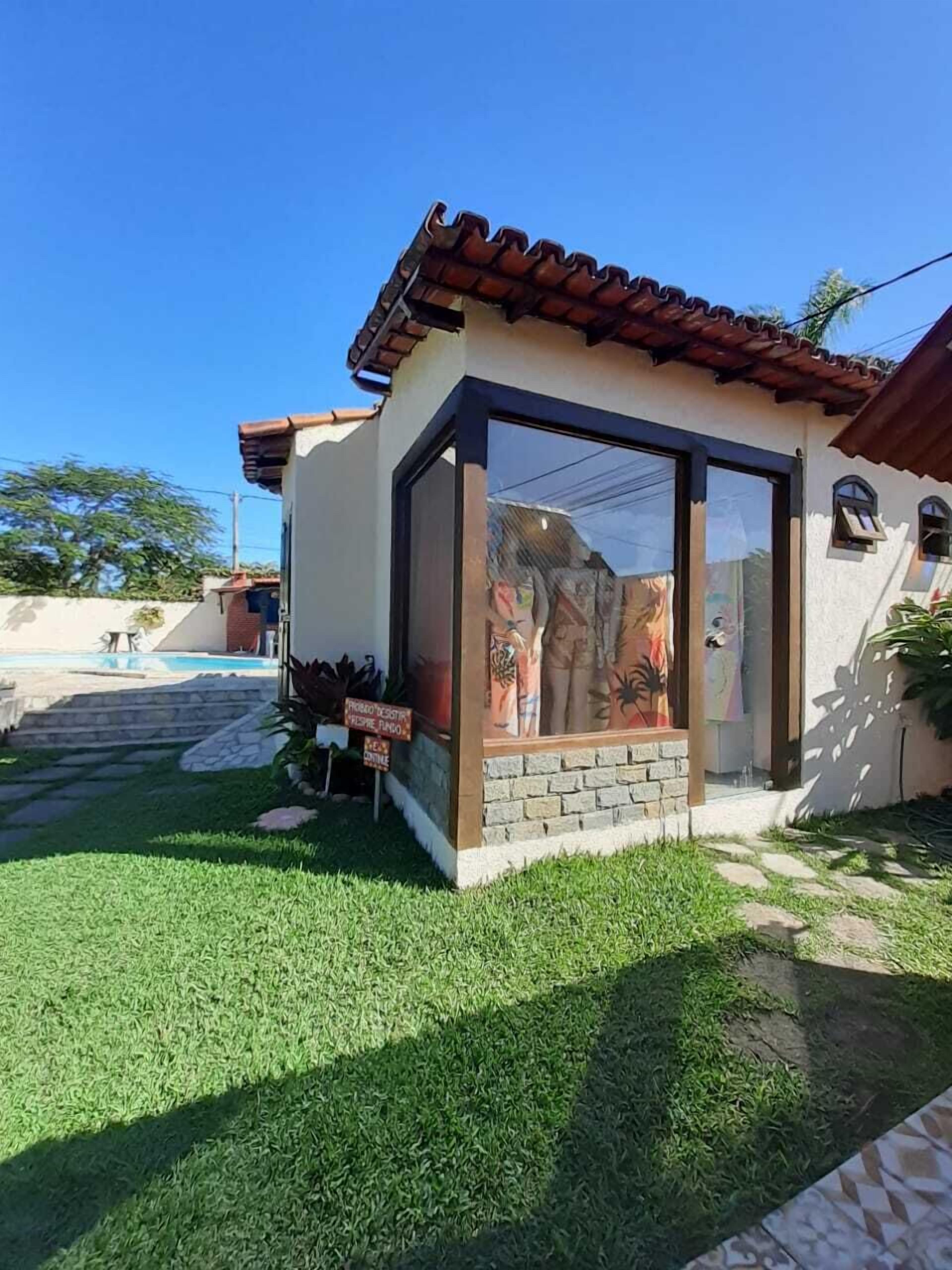 A house with a tiled roof, a glass door, and a small garden.