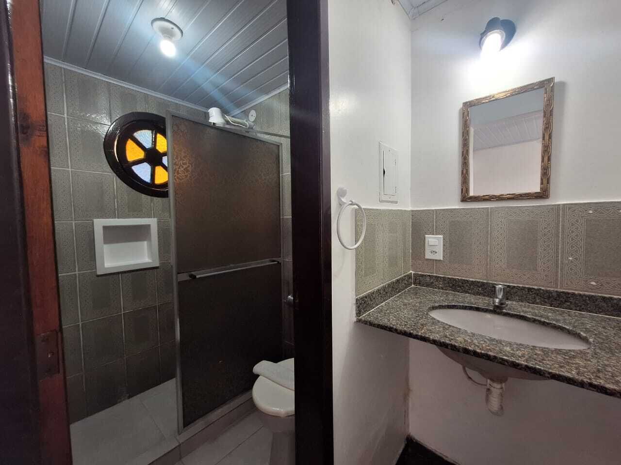 A bathroom with a shower, toilet, and sink.