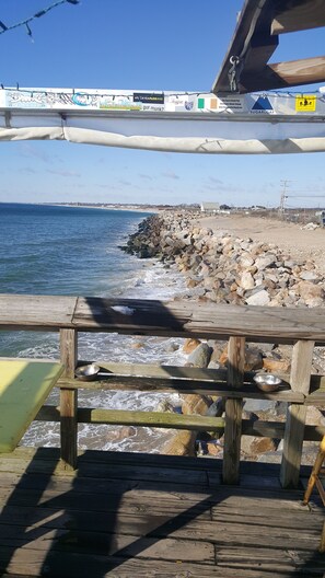A wooden deck with a metal railing overlooking a rocky beach and the sea. - Conveniently located in a private association very close to beaches. (Charlestown)