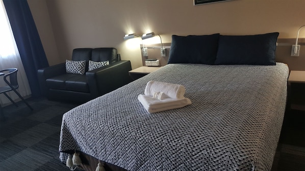 Escritorio, tabla de planchar con plancha y ropa de cama