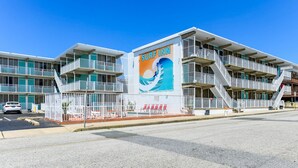 A multi-story building with a prominent 'Surf Inn' sign, featuring a wave graphic. - Surf Inn Suites (Ocean City)