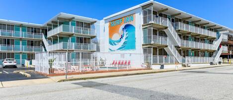 A multi-story building with a prominent 'Surf Inn' sign, featuring a wave graphic.