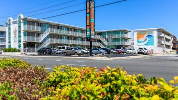 A Surf Inn motel with multiple balconies, a parking lot, and a clear blue sky.