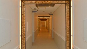 A hotel hallway with a patterned frame and illuminated floor lights, leading to multiple rooms. - TERRACE M YOKOTA BASE - Adults Only (Mizuho)