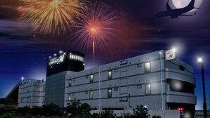 A hotel with a prominent 'HOTEL' sign, a large moon in the sky, and fireworks in the background. - TERRACE M YOKOTA BASE - Adults Only (Mizuho)