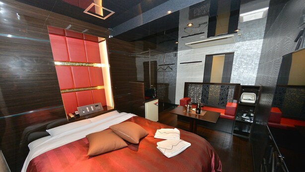 A modern hotel room with a large bed, a desk, and a seating area. - TERRACE M YOKOTA BASE - Adults Only (Mizuho)