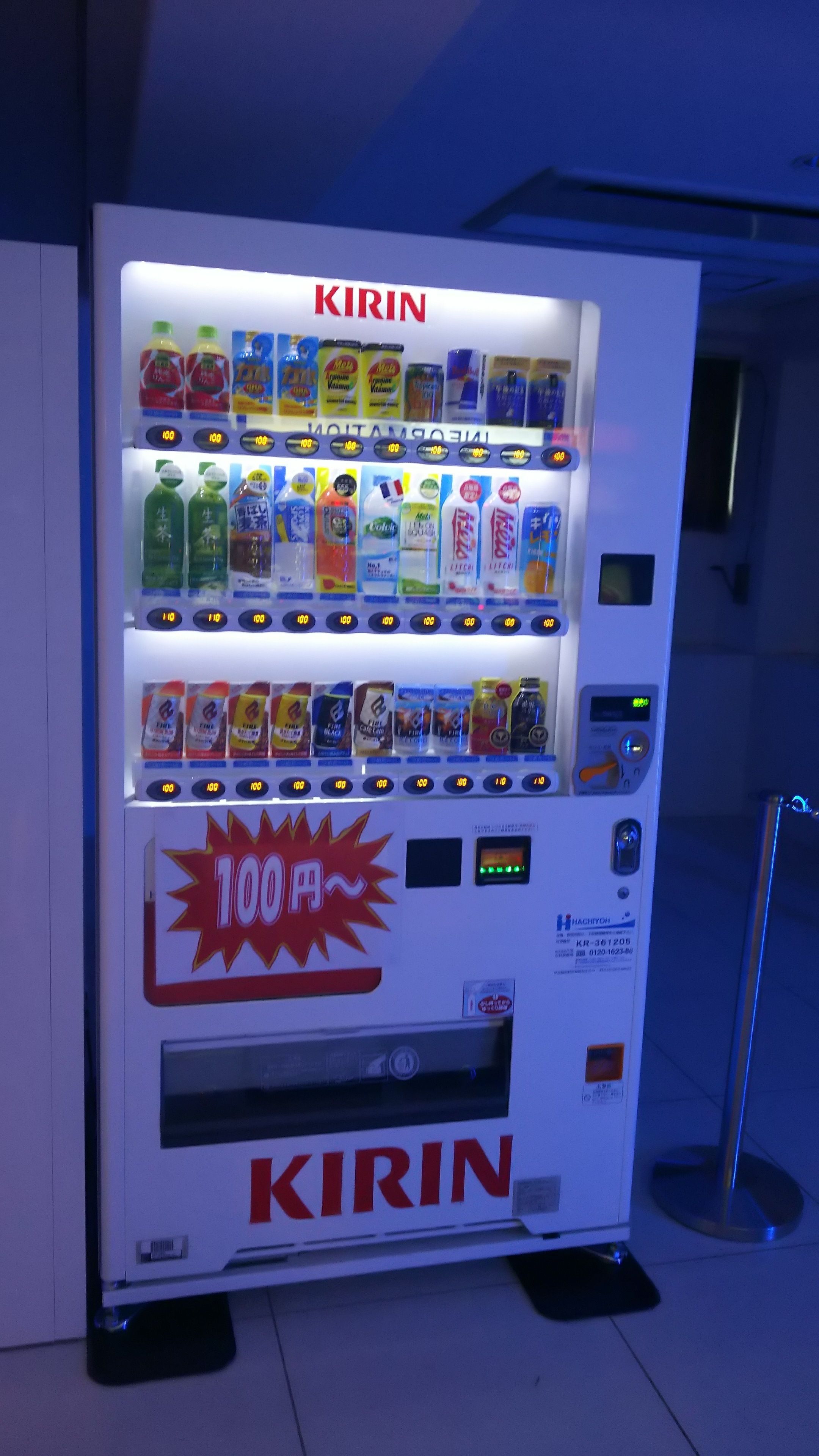 A vending machine with the brand name 'KIRIN' prominently displayed. It contains various beverage options, including cans and bottles, with price labels visible.