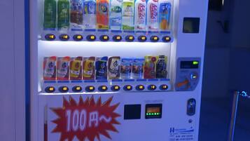 A vending machine with the brand name 'KIRIN' prominently displayed. It contains various beverage options, including cans and bottles, with price labels visible.