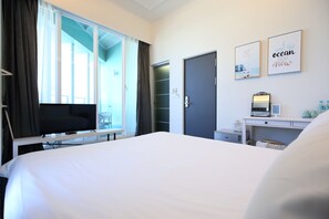 Comfortable room with a large bed, flat-screen TV, and desk with computer and mirror.