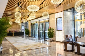 A modern lobby with a polished marble floor, wooden ceiling panels, and decorative spherical lights. - Shanshui S Hotel Maliandao (Beijing)