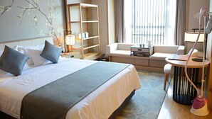 A hotel room with a large bed, a sofa, a desk, and a standing lamp. - Shanshui S Hotel Maliandao (Beijing)