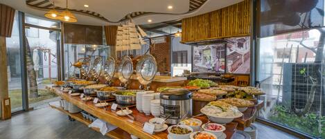 A buffet with various food items and a large window with a view of the outdoors.