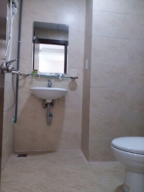 A bathroom with a white sink, a mirror above it, and a toilet.
