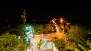 A nighttime view of a road with streetlights and palm trees. -  B'Lan Riverside Villa (Da Nang)