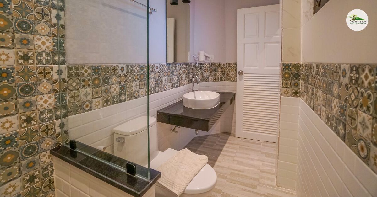 A bathroom with a tiled wall, a sink, a toilet, and a mirror.