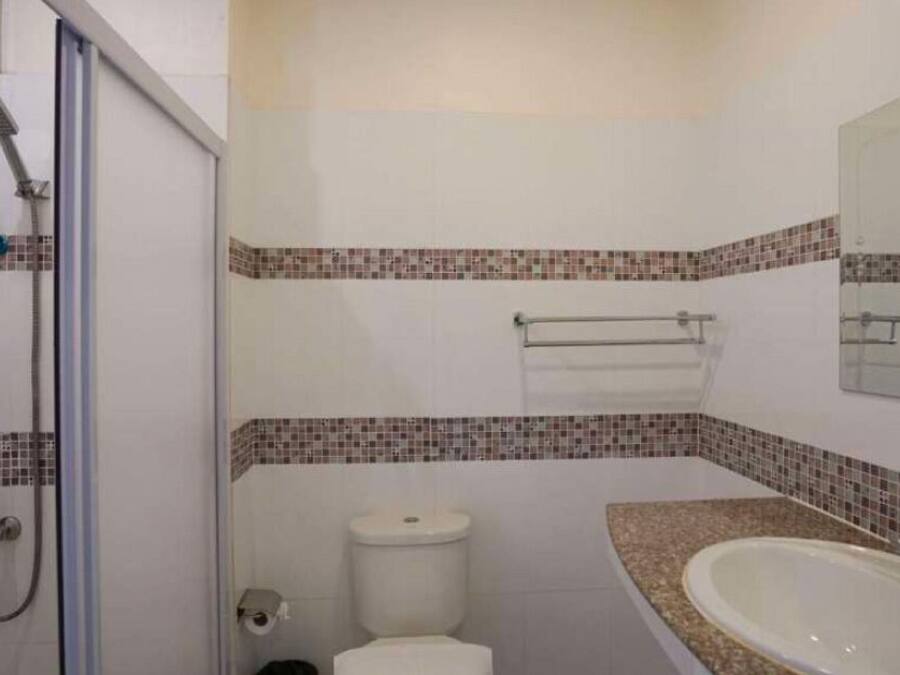 A bathroom with a shower, toilet, and sink.