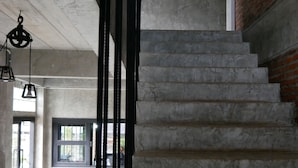 Uma escada com uma parede de tijolos de um lado e um chão de concreto do outro.