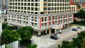A multi-story hotel with a symmetrical facade, large windows, and a prominent entrance with a sign. - Vienna Hotel Qingyuan Taihe Ancient Cave (Qingyuan)