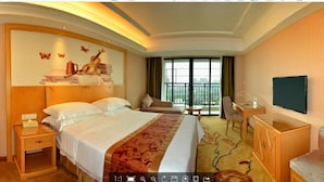 A hotel room with a large bed, a desk, a chair, a TV, and a window with a view. - Vienna Hotel Qingyuan Taihe Ancient Cave (Qingyuan)