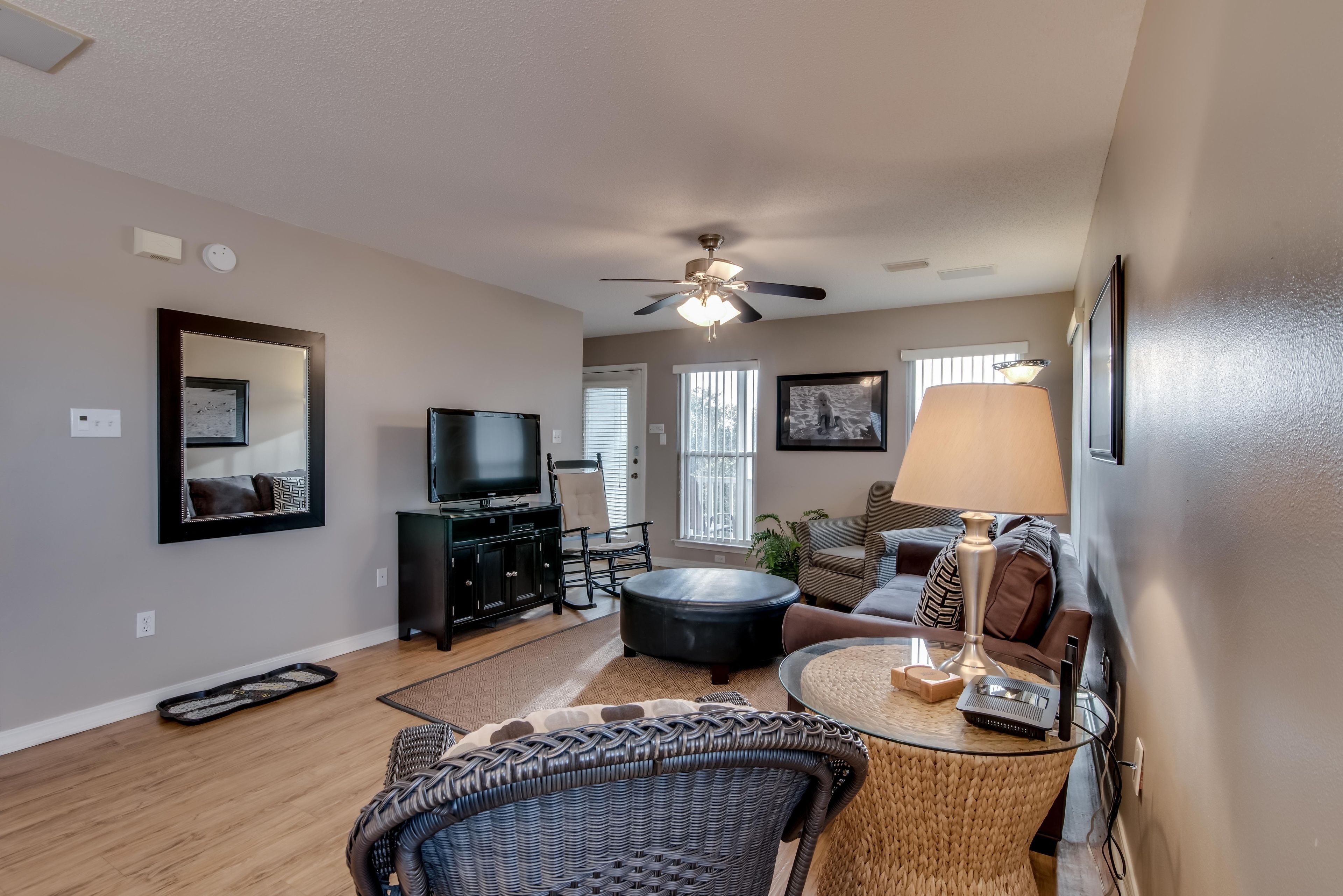A living room with a ceiling fan, a television, a sofa, a coffee table, and a dining table.
