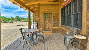 Esterno in legno con patio coperto, una porta di legno e un cartello con scritto "WOODY'S BUNKHOUSE".