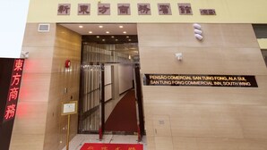 A multi-story building with a modern facade, featuring large windows and a red carpet entrance. - San Tung Fong Commercial Inn South Wing (Macau)