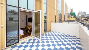 A hotel room with a checkered floor, large windows, and a view of the cityscape. - San Tung Fong Commercial Inn South Wing (Macau)
