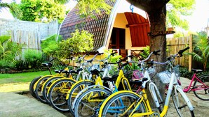 Eine Reihe gelber Fahrräder, abgestellt vor einem Gebäude mit der Aufschrift 'RENT A BICYCLE'.