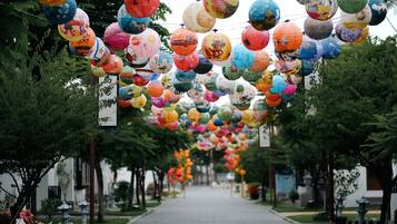 Un sendero bordeado de árboles y decorado con coloridos farolillos de papel.