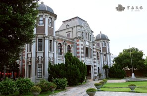 A large, historic building with multiple domes and columns, surrounded by well-maintained gardens and pathways. - Gh House (Lukang)