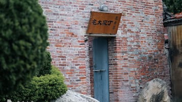 A brick building with a blue door and a signboard.