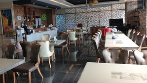 A modern restaurant with a bar area, seating with wooden chairs and tables, and a patterned wall. - Khan Hotel (Daegu)