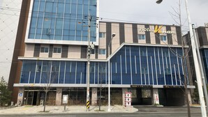 A modern hotel building with large glass windows and a sign reading "Hotel Khas". - Khan Hotel (Daegu)