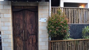 A wooden double door with a sign above it reading "Meisya Cottage." - Meisya Cottage (Gili Trawangan)