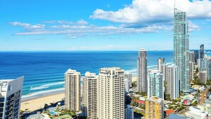 A coastal cityscape with high-rise buildings, a beach, and the ocean.