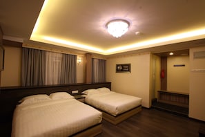 A hotel room with two beds, a large mirror, a ceiling light, and a fire extinguisher. - Shamrock Guest House (Ipoh)