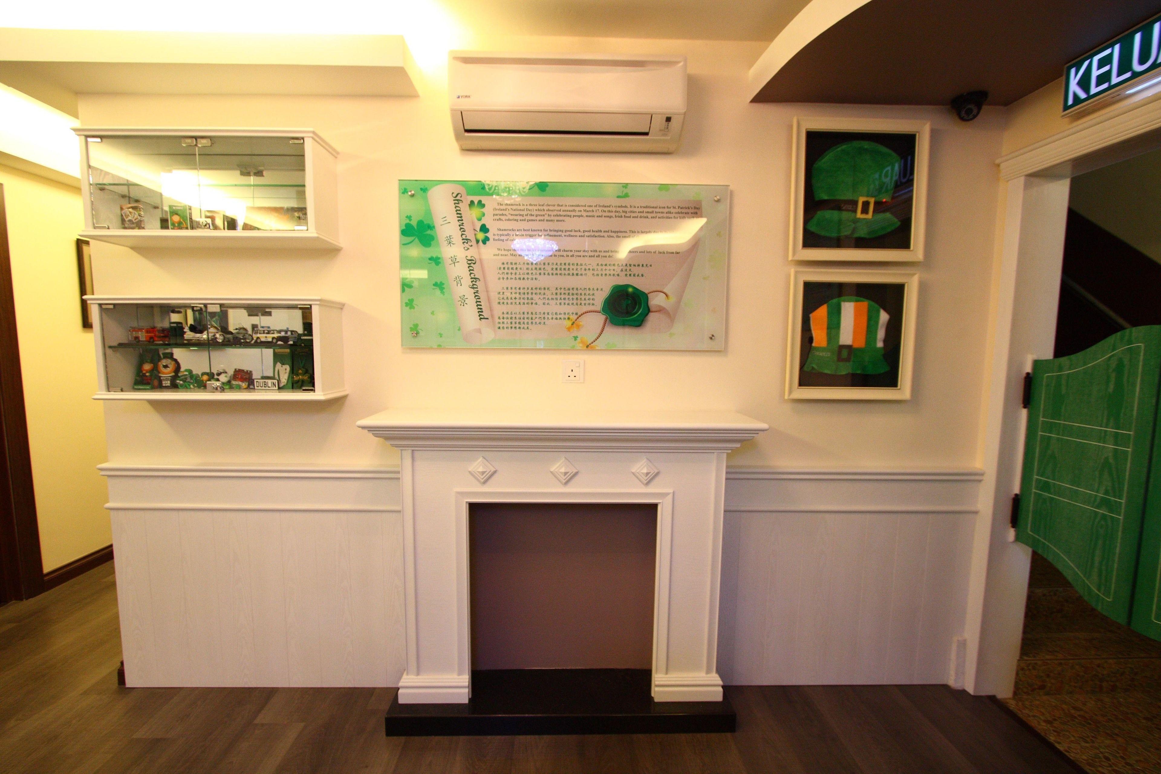 Una habitación con chimenea blanca, aire acondicionado instalado y un cartel verde con texto.