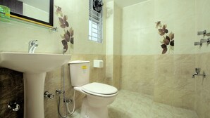 Une salle de bain avec un lavabo, des toilettes et une douche.
