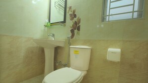 Une salle de bain avec des toilettes, un lavabo et un miroir.