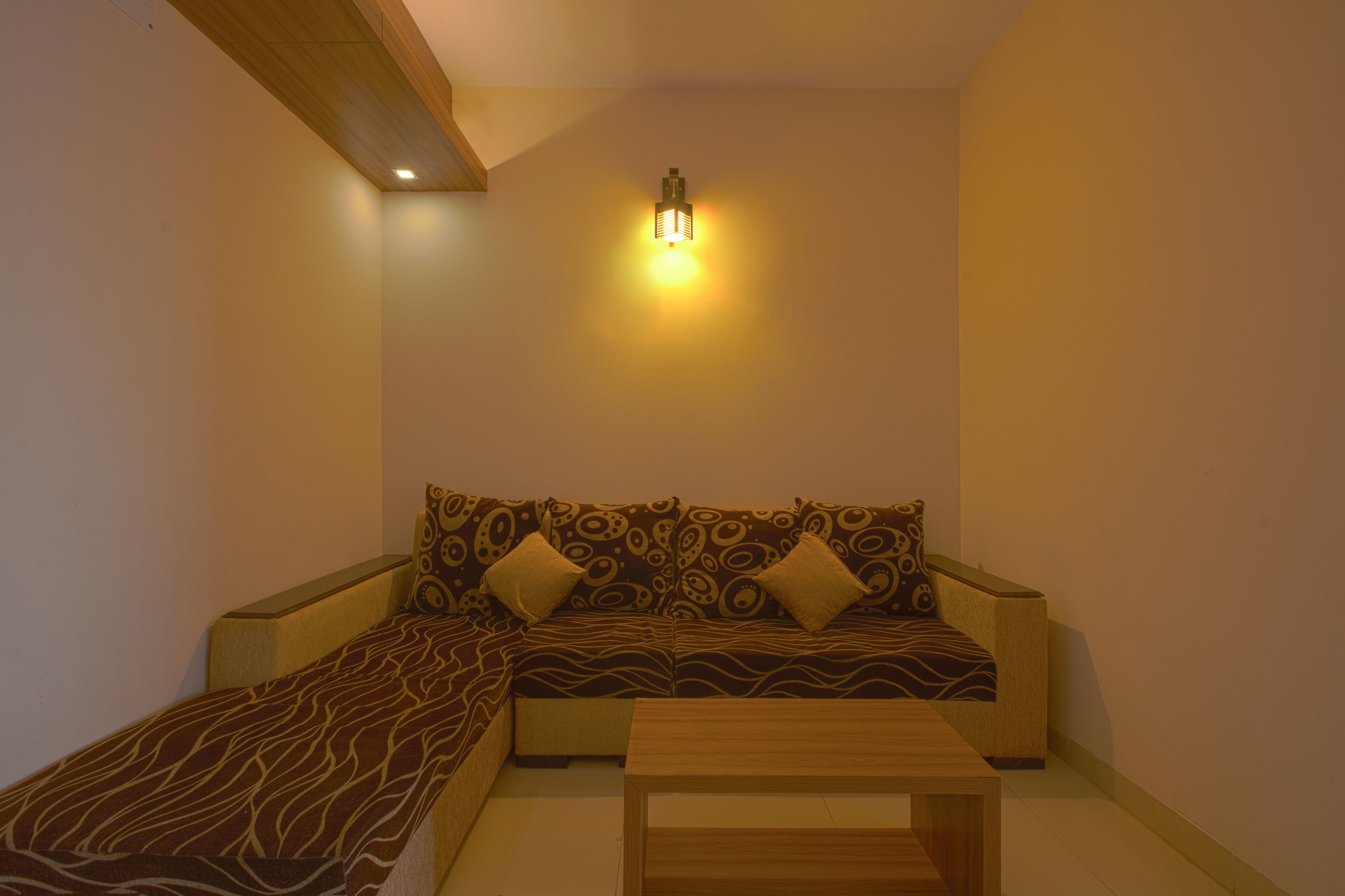A modern living room with a sofa, a coffee table, and a wall-mounted light fixture.