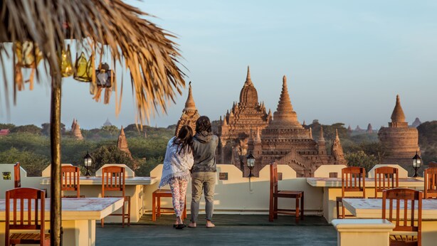 A terrace with wooden chairs and tables, overlooking ancient temple structures. - Hotel Temple View Bagan (Nyaung-U)