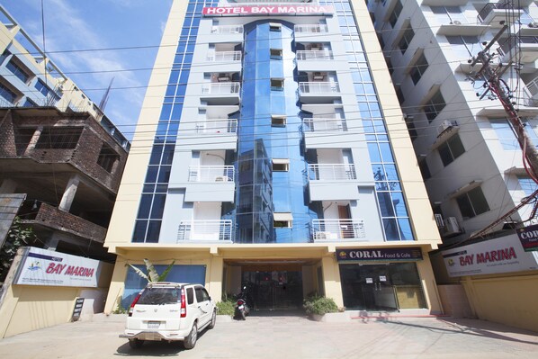 A multi-story hotel with a prominent blue glass facade and balconies.