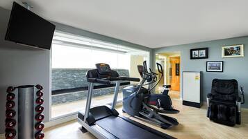 A modern gym with treadmills, ellipticals, and weight machines.