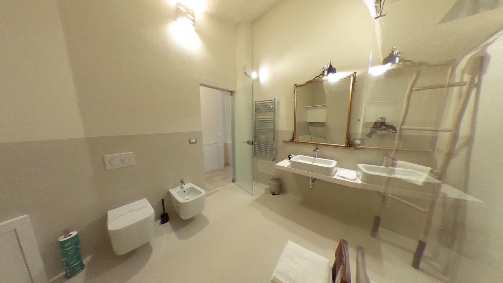 A modern bathroom with a bidet, a toilet, a sink, and a mirror.