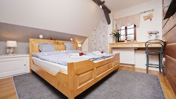 A bedroom with a wooden bed, a desk, and a chair.